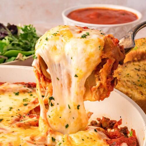 A spoon of Skillet Lasagna being scooped out of the pan.