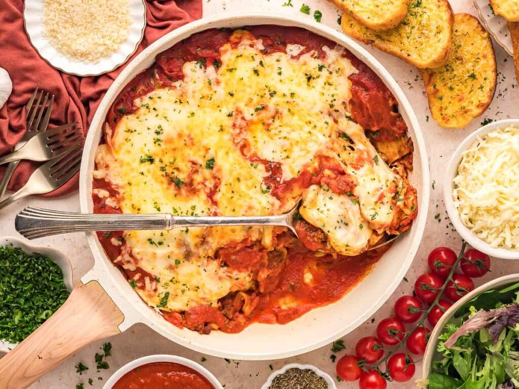 Cooked Skillet Lasagna in a pan with a spoon.