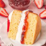 A slice of Victoria sponge on a white plate.