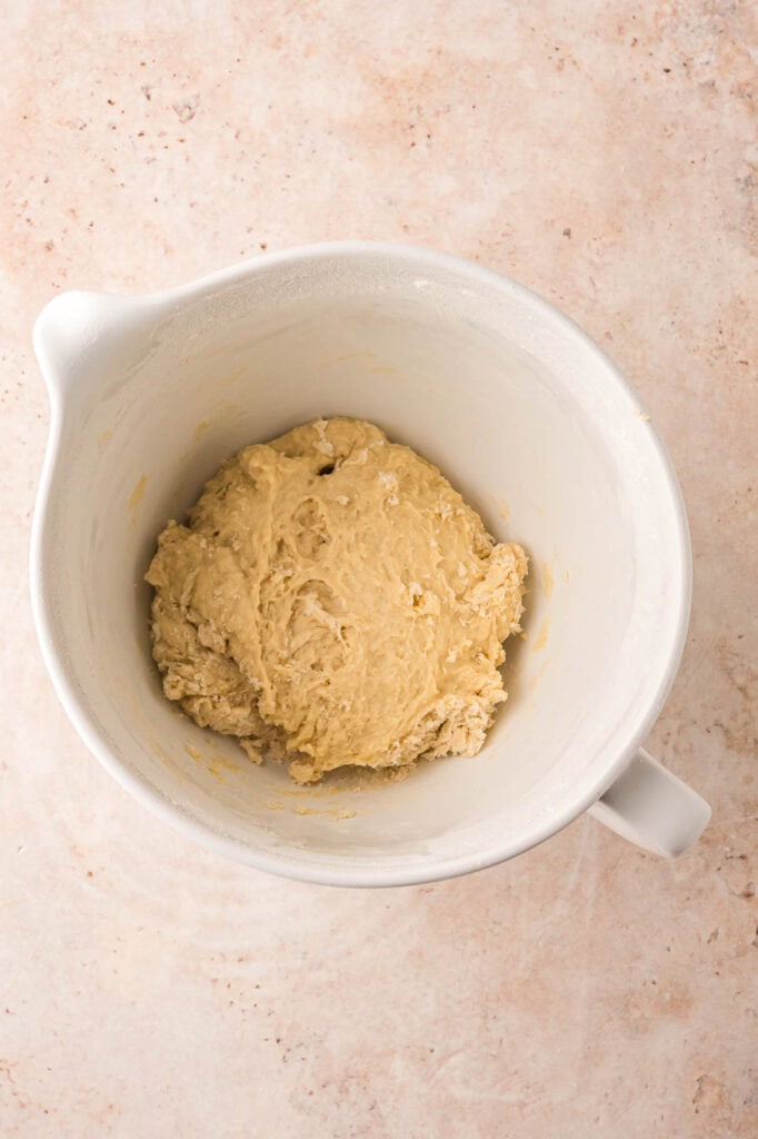 A rough dough formed in the mixing bowl.