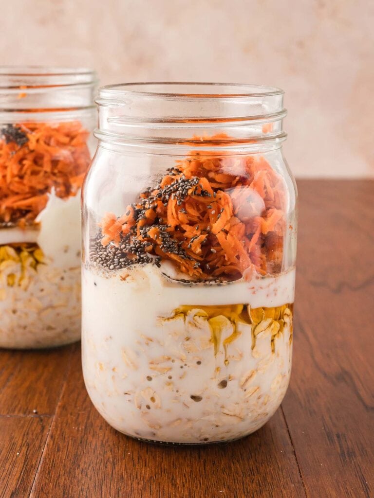 Grated carrots and chia seeds added to the jar with the oat mixture.