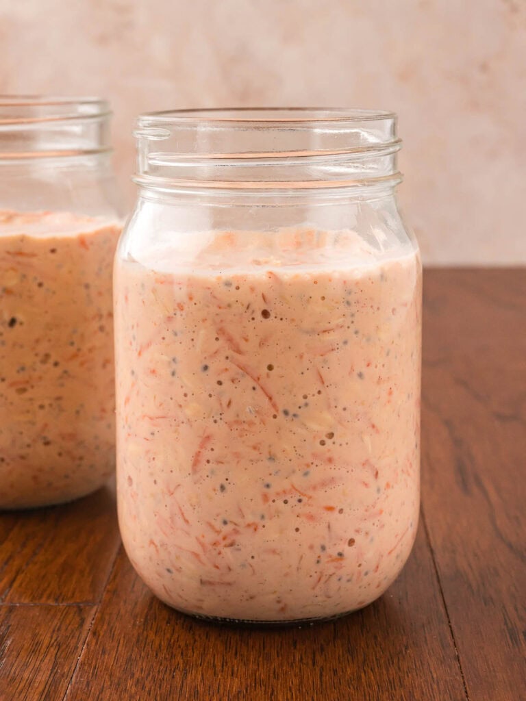 All the ingredients for carrot cake overnight oats mixed together in a jar.