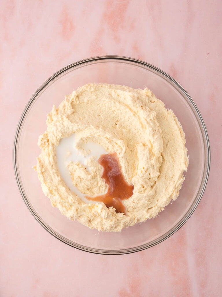 Vanilla and milk being added to the batter.