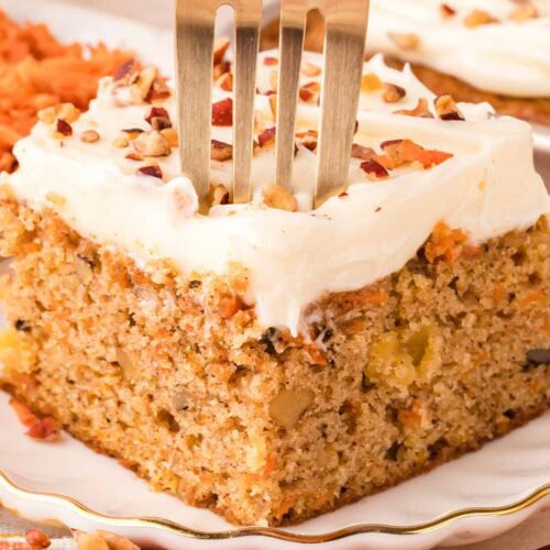 A fork slicing into the carrot cake sheet cake.