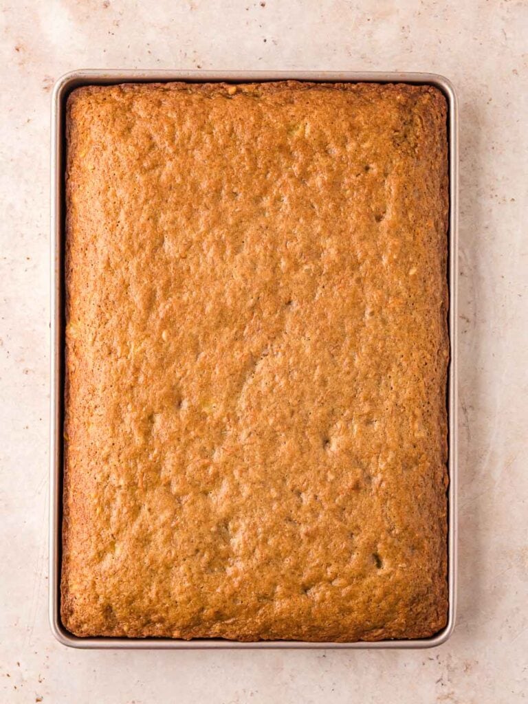 A cooked carrot cake sheet cake in a 9x13 pan.