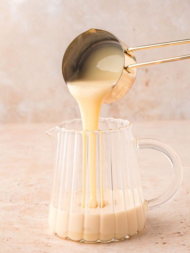 The two milks and heavy cream being poured into a glass jug.