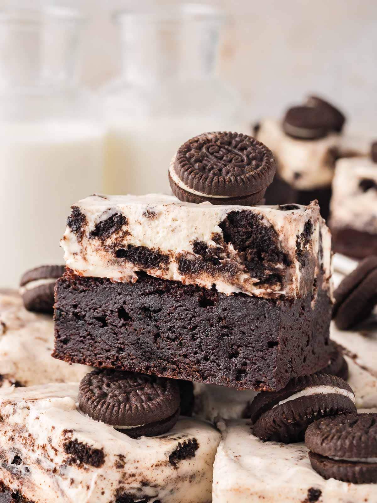 Stacked Oreo cheesecake brownies with rich chocolate brownie bases and fluffy Oreo cheesecake layers, topped with mini Oreos.