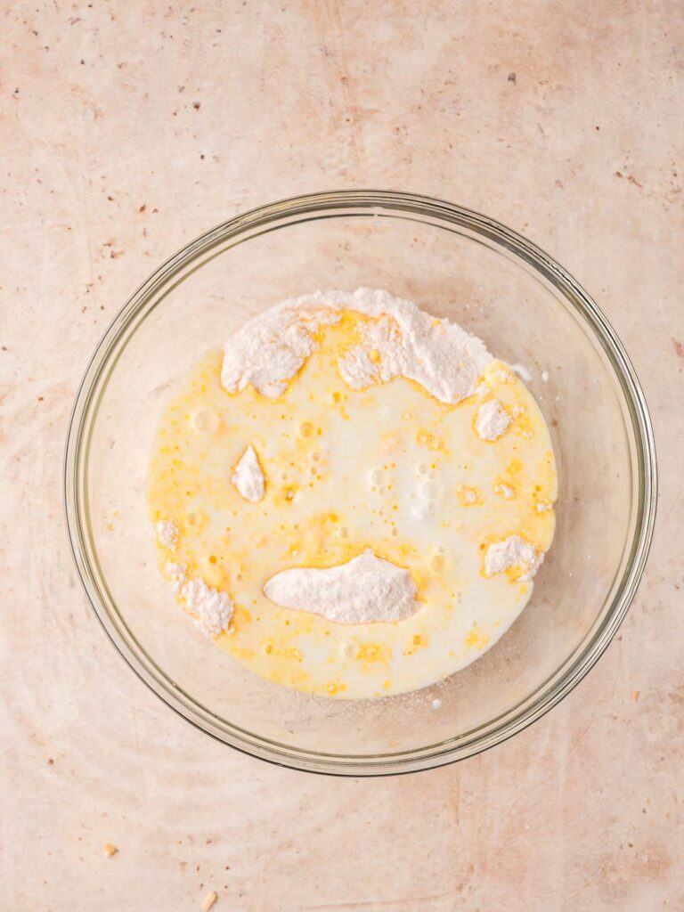 nstant vanilla pudding mix combined with milk in a glass bowl, ready to be whisked.