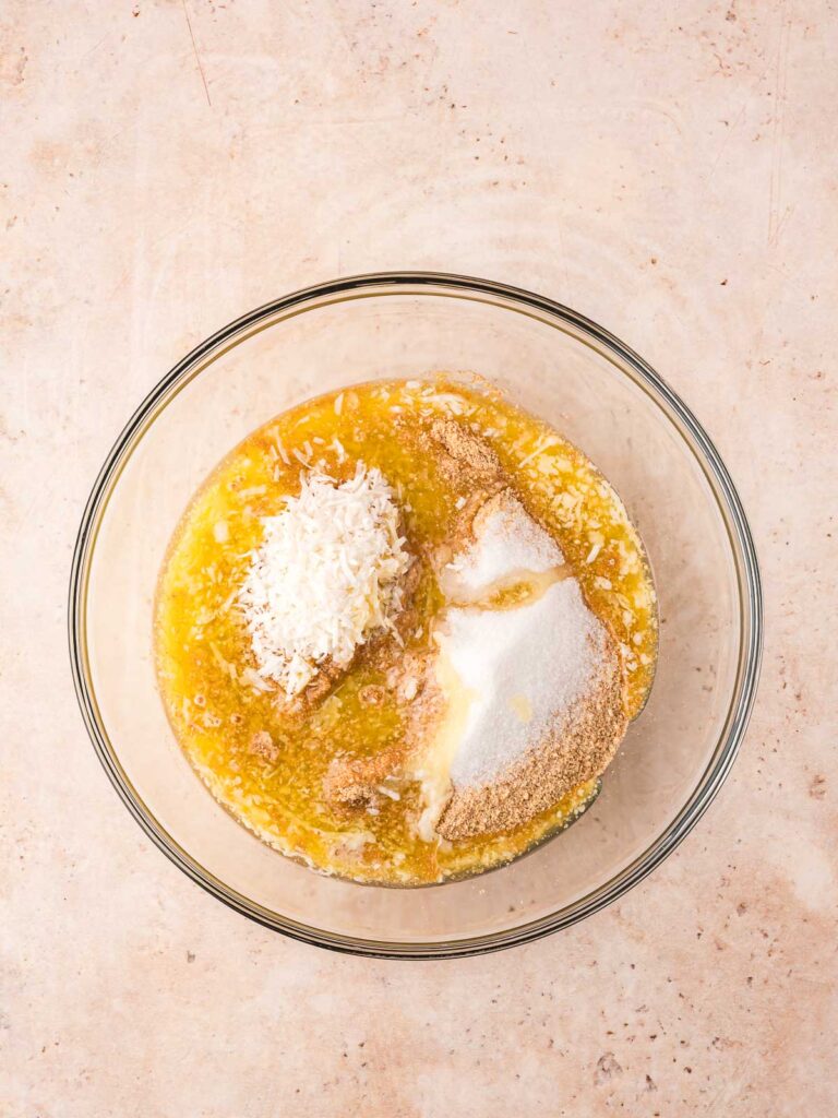 Graham cracker crumbs, sugar, shredded coconut, and melted butter in a bowl before mixing.