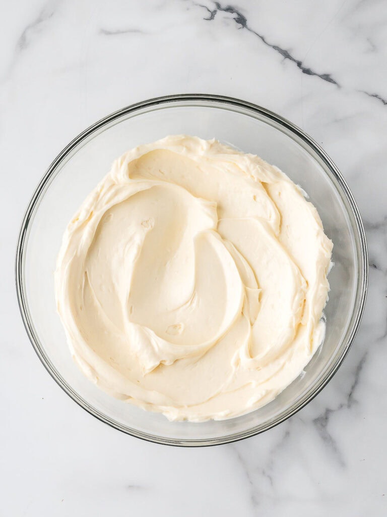 Smooth cream cheese mixture in a glass bowl, ready for the whipped cream.