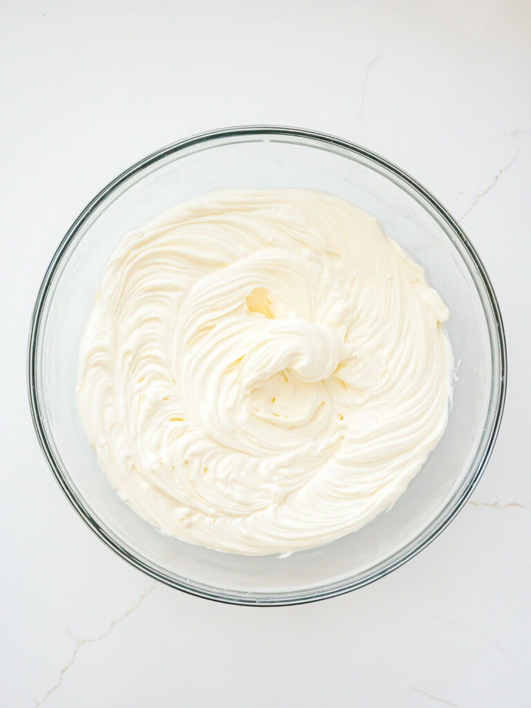 Whipped cream cheese, sugar and vanilla in a bowl.