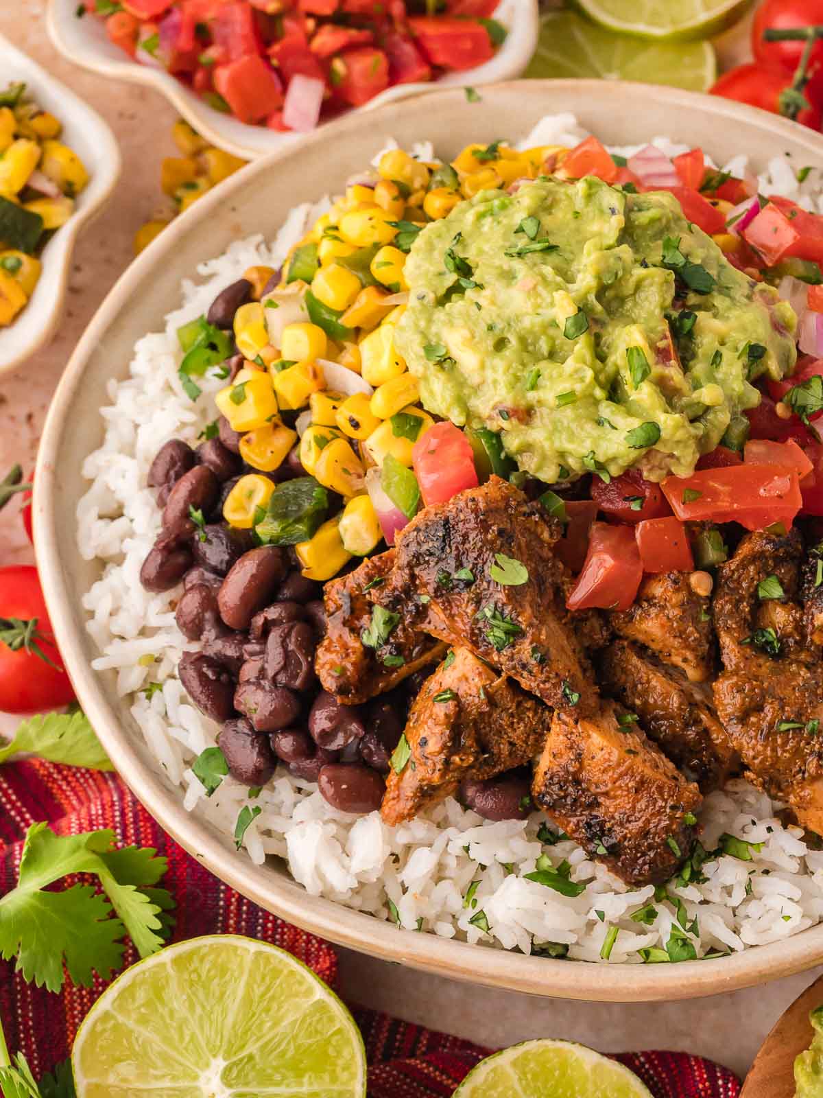 Close-up of a Chipotle chicken burrito bowl with cilantro-lime rice, black beans, corn salsa, tomato salsa, and guacamole.
