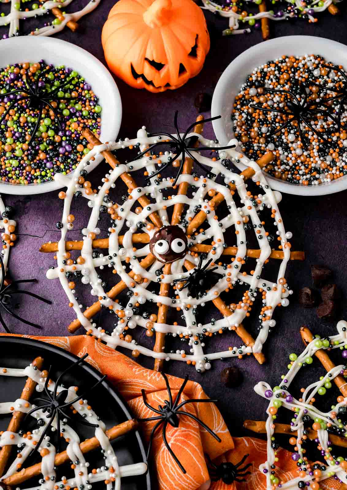 Close-up of a Halloween Pretzel Spider Web made with pretzels, white chocolate, candy eyes, and colorful sprinkles.