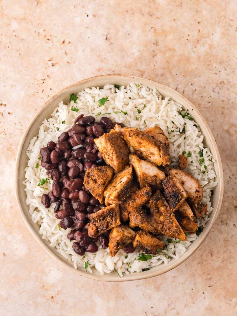 Burrito bowl with a base of cilantro-lime rice and black beans, topped with chopped chicken.