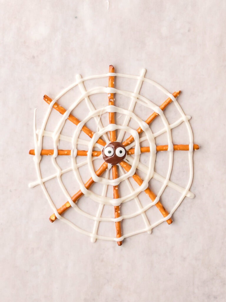 Pretzel Spider Web decorated with white chocolate spiral and candy eyeball in the center.