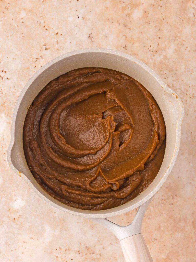 Fully cooked pumpkin butter in a saucepan with a smooth, glossy swirl ready for cooling and storing.