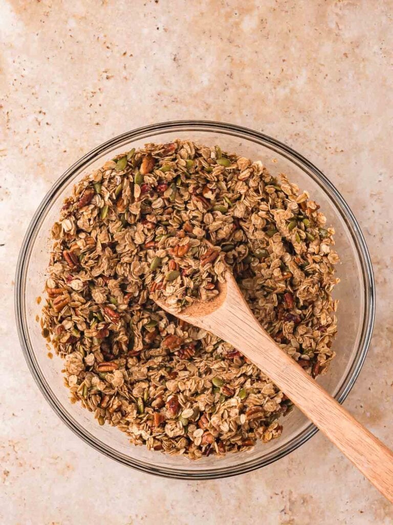 Granola mixture stirred together with the maple syrup mixture.