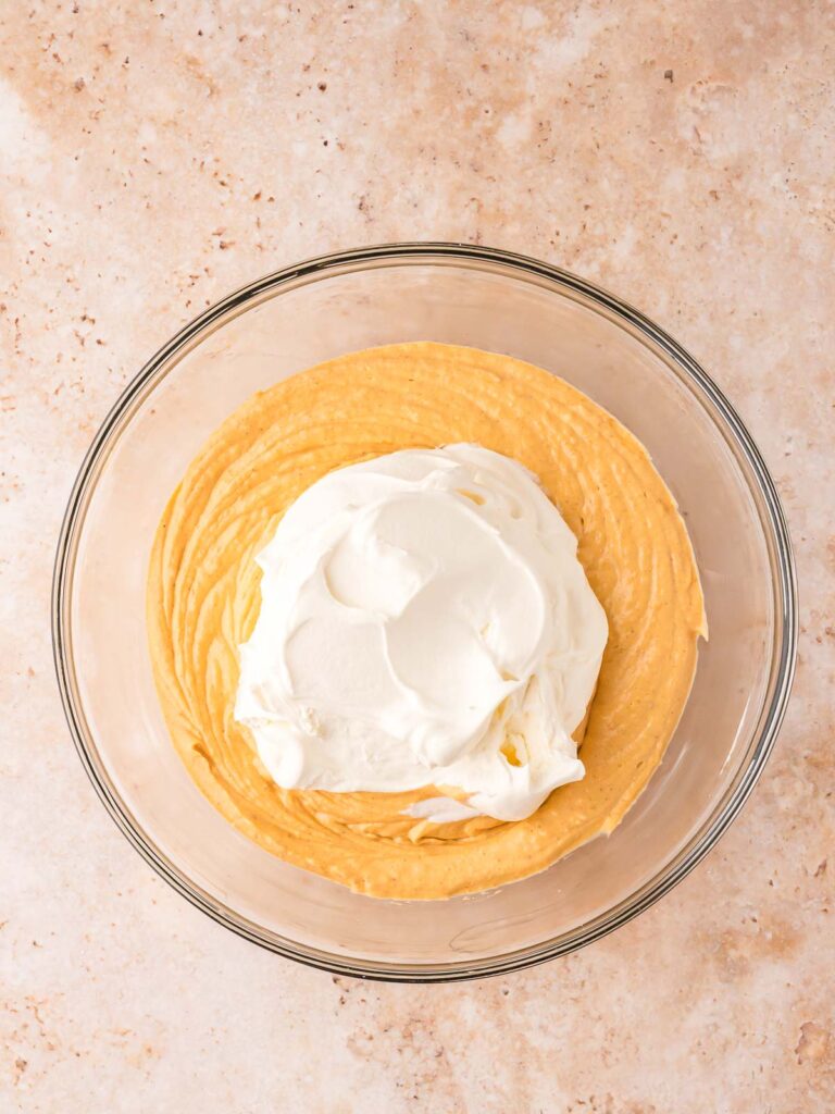 Pumpkin cheesecake filling with Cool Whip folded in before layering into pumpkin pie cheesecake cups.