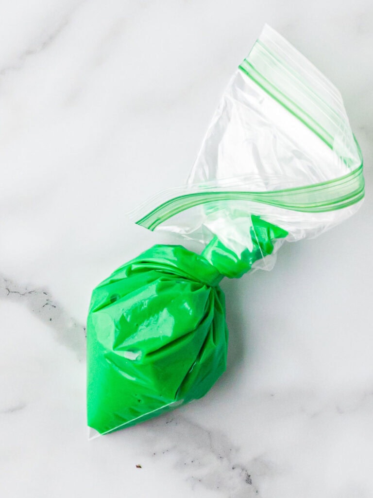 Zip-top bag filled with green icing for decorating Rice Krispie Pumpkins.