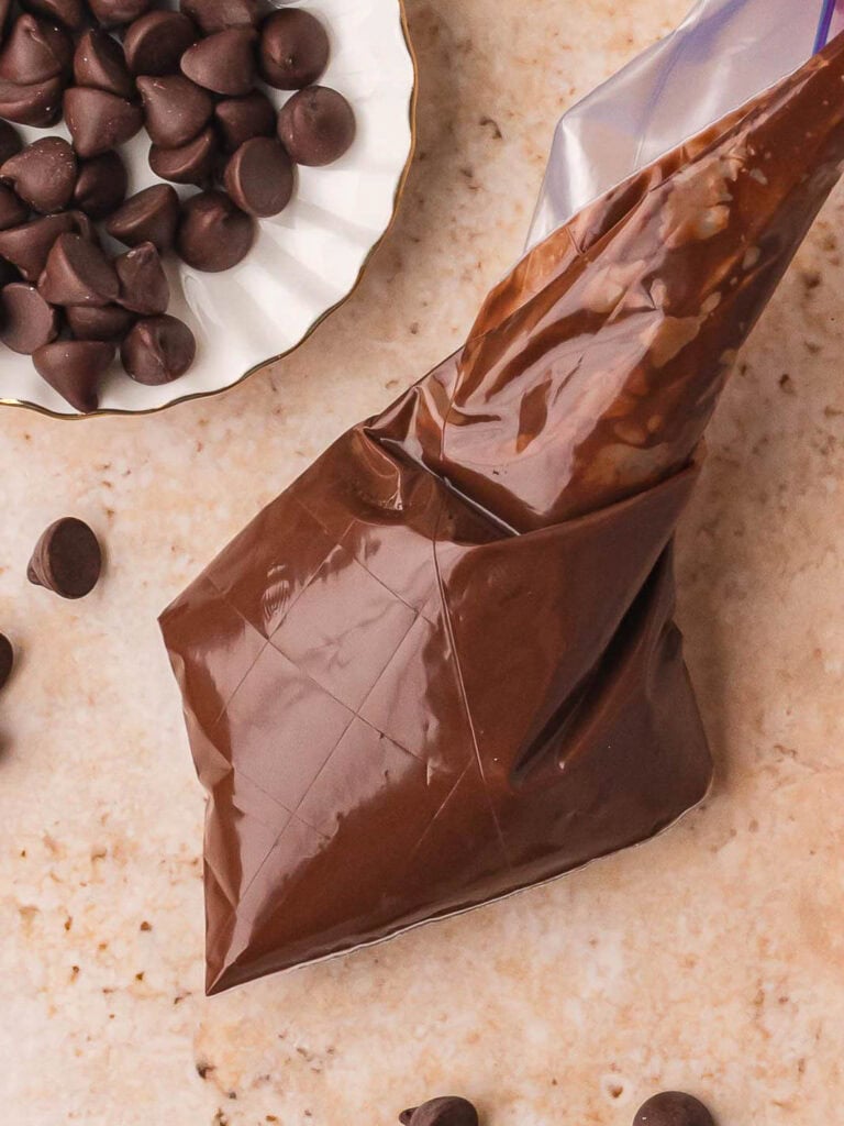 A piping bag with melted chocolate to pipe the tree shapes.