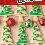 Decorated Christmas tree sugar cookies with colorful icing and ornaments on a holiday tray.