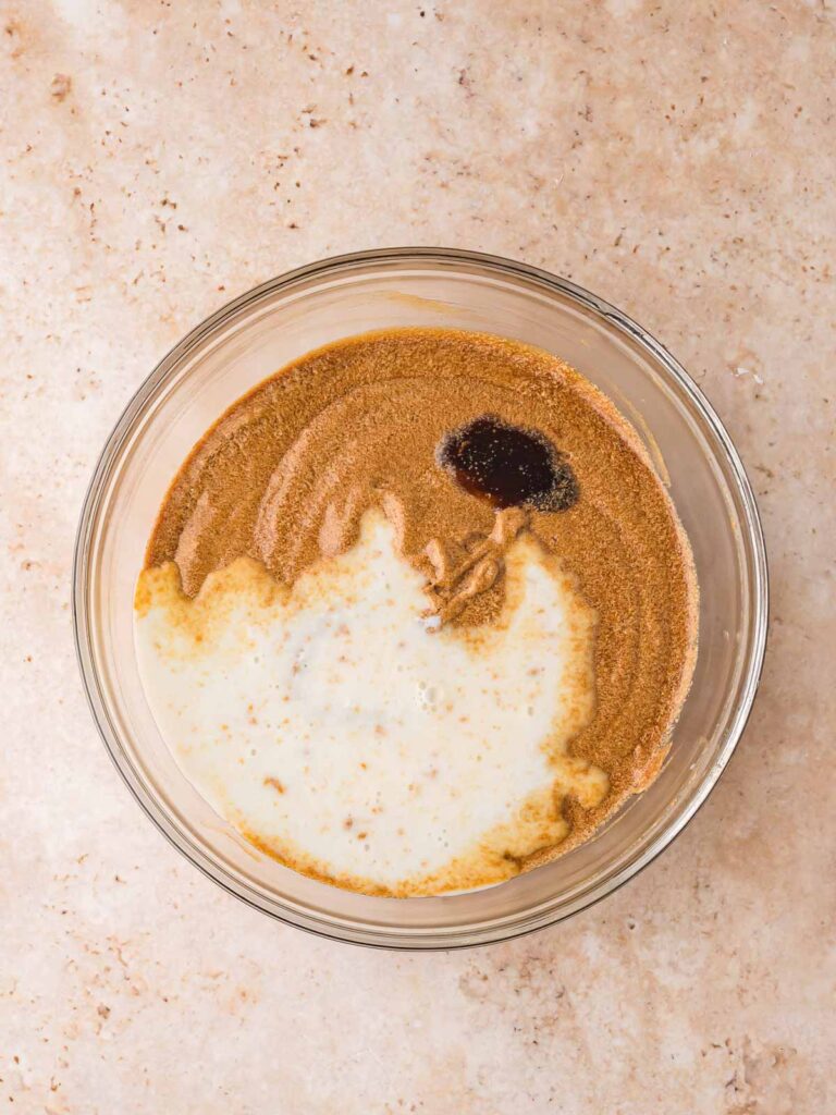 Mixing molasses, milk, and vanilla for Gingerbread Cake in a glass bowl.