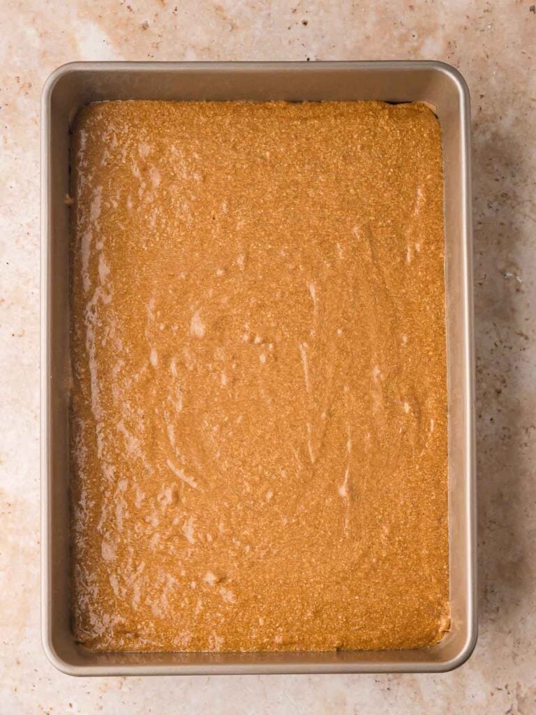 Gingerbread Cake batter poured evenly into a 9x13-inch baking pan before baking.