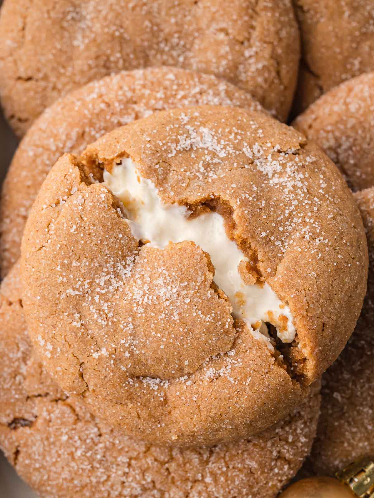 Close-up of a Gingerbread Cheesecake Cookie broken open to reveal the creamy cheesecake filling inside.