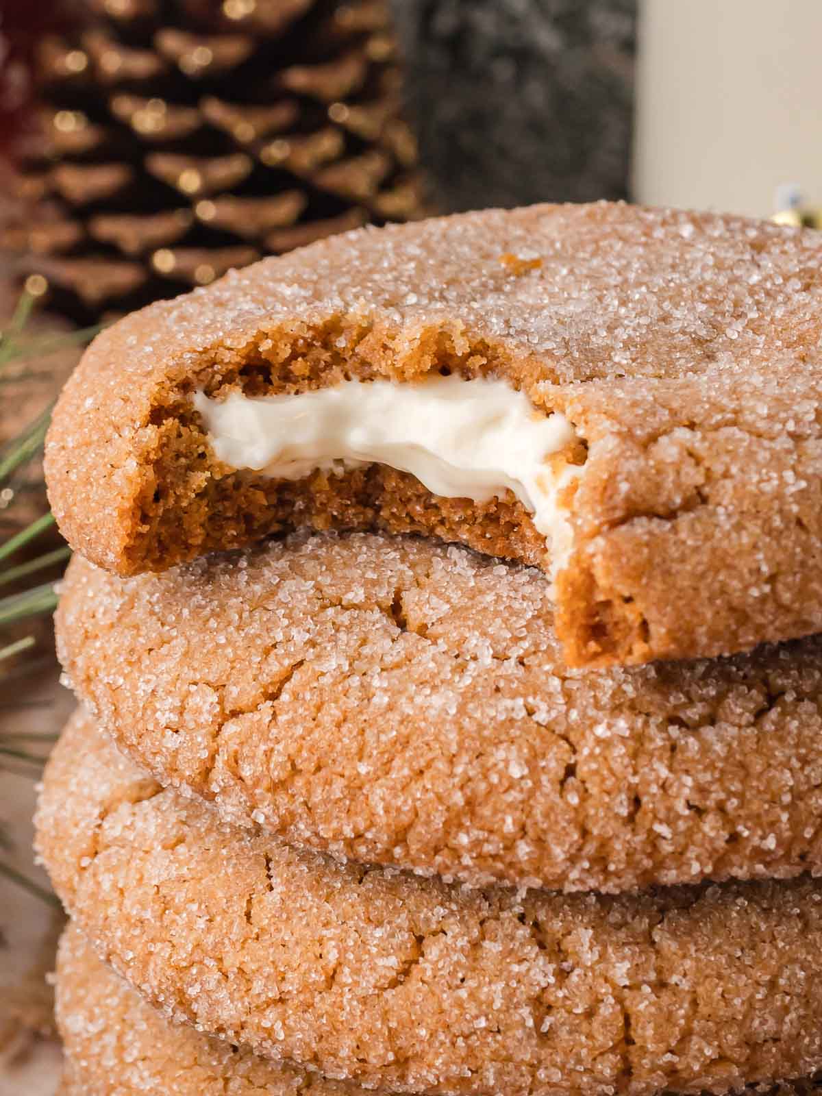 Stack of Gingerbread Cheesecake Cookies showing a bite revealing the smooth cream cheese filling.