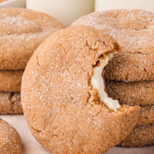 Soft Gingerbread Cheesecake Cookie with a bite taken out, showing creamy cheesecake center and sugar-coated edges.