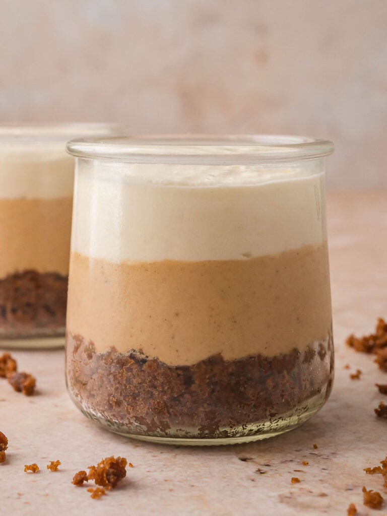 Layer of whipped cream spread evenly over the cheesecake filling in the Mini Gingerbread Trifle.