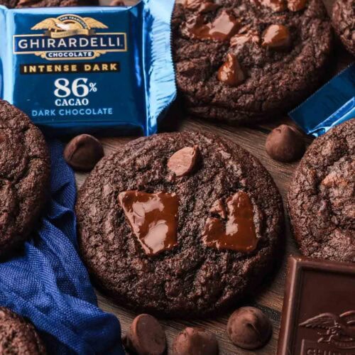 Double Chocolate Chunk Cookies made with Ghirardelli dark chocolate, surrounded by chocolate squares and chips.