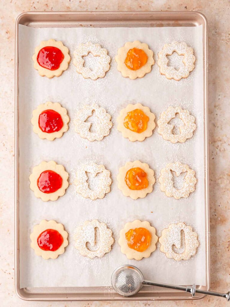 Cookie tops dusted with powdered sugar and ready to be placed over the jam.
