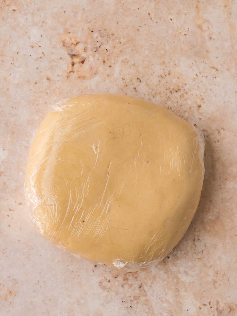 Smooth Linzer cookie dough wrapped and chilled before rolling.