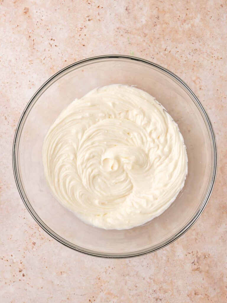 Cream cheese mixture whipped in a glass bowl for the cheesecake filling.