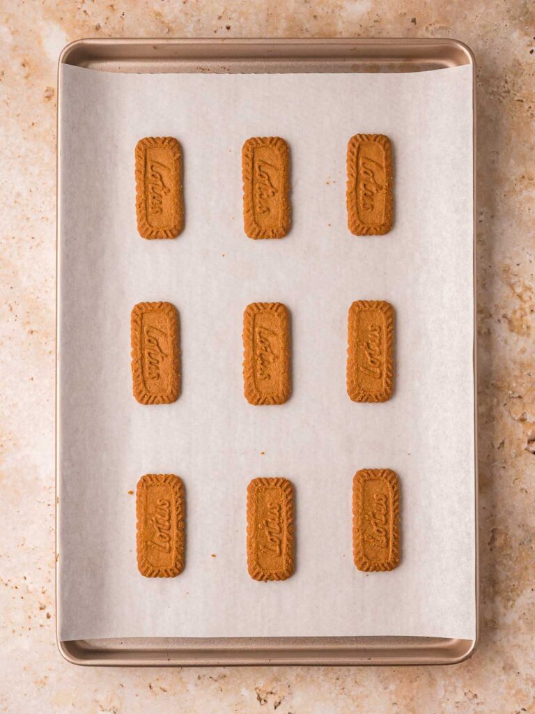 A baking sheet with parchment paper and placing Biscoff cookies for Chocolate Christmas Trees.