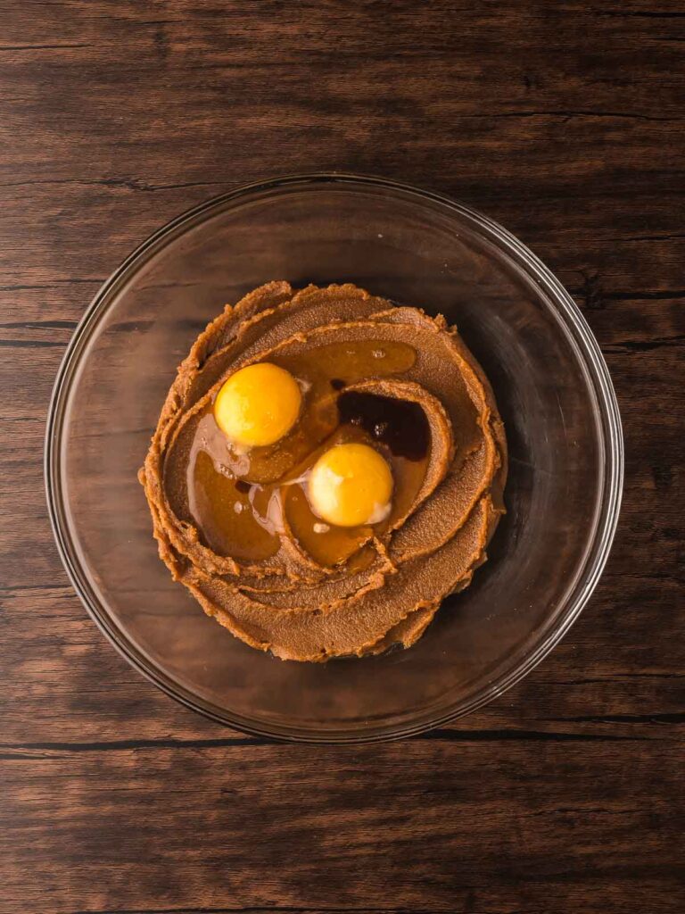 Two eggs and vanilla extract added to the creamed butter and sugar mixture for Double Chocolate Chunk Cookie dough.