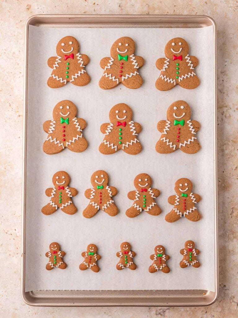 Tray of decorated Gingerbread Man Cookies with white icing and colorful buttons ready to serve.
