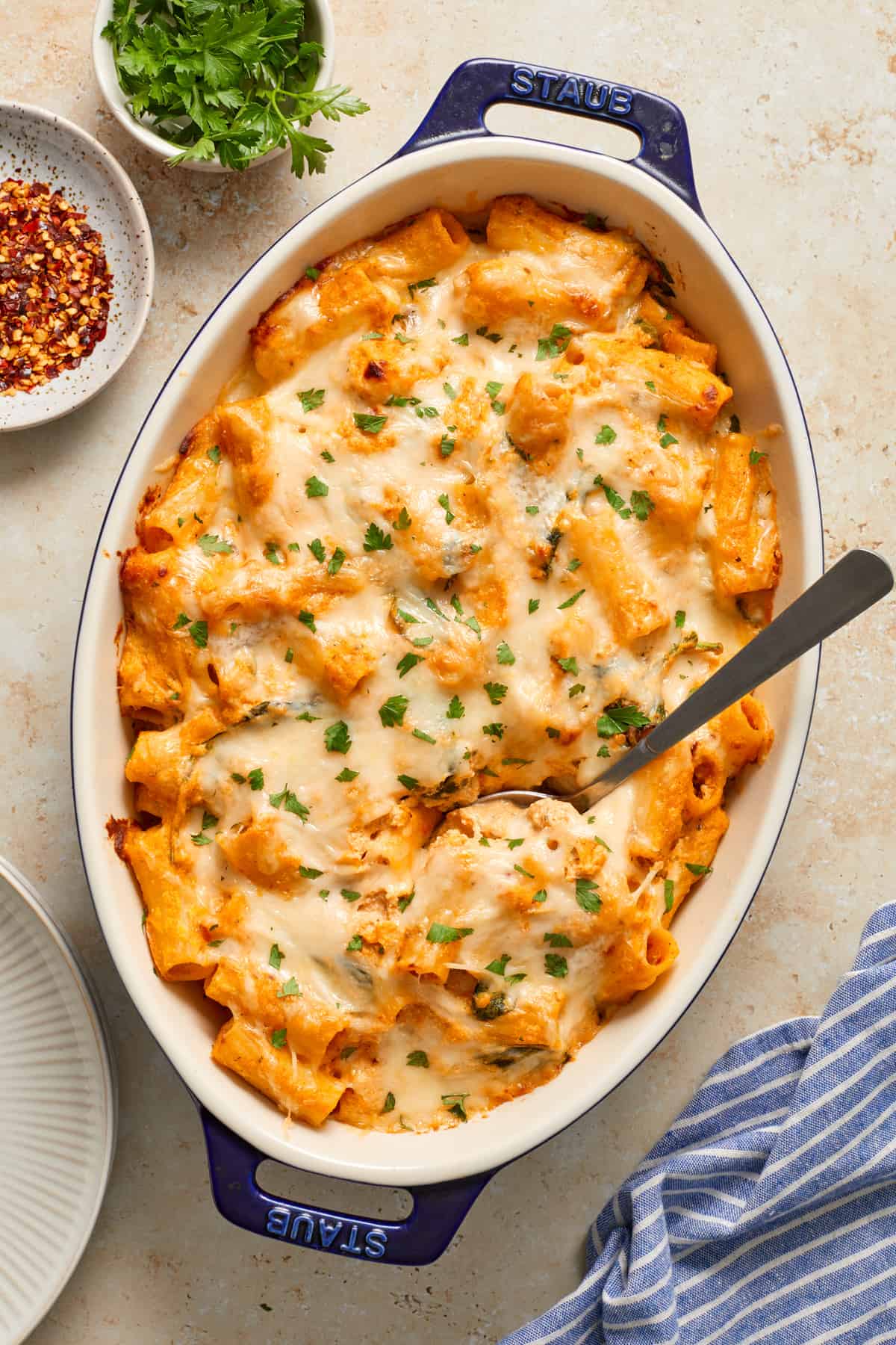 Overhead shot of pumpkin ricotta pasta bake with a spoon in the casserole dish.