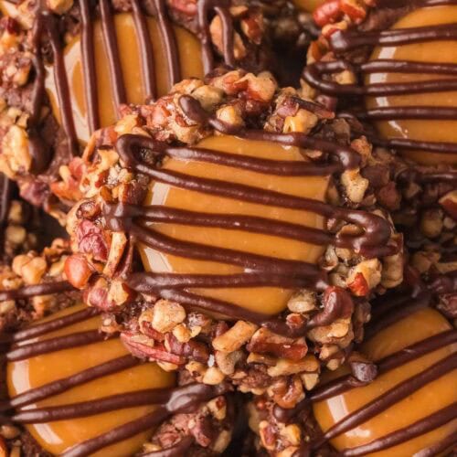 Close-up of Turtle Thumbprint Cookies with caramel centers and chocolate drizzle.