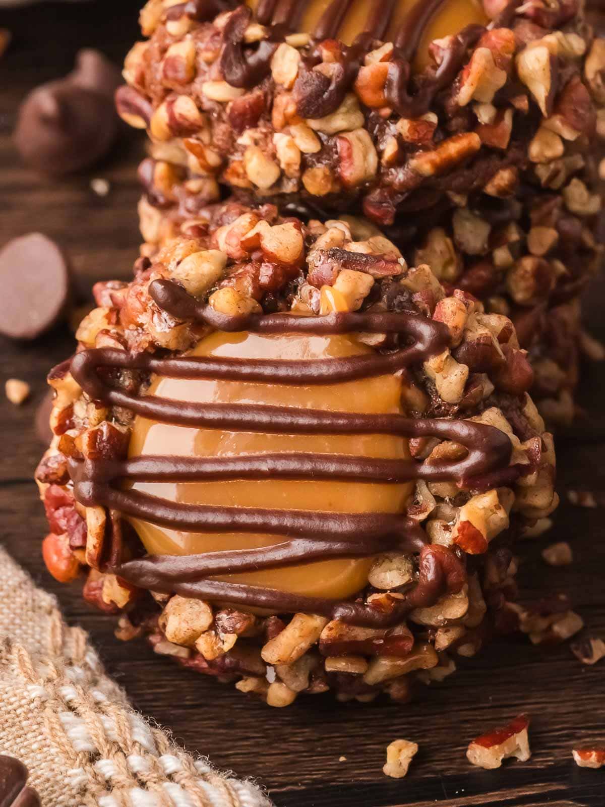 Single Turtle Thumbprint Cookie showing caramel filling and chocolate drizzle.