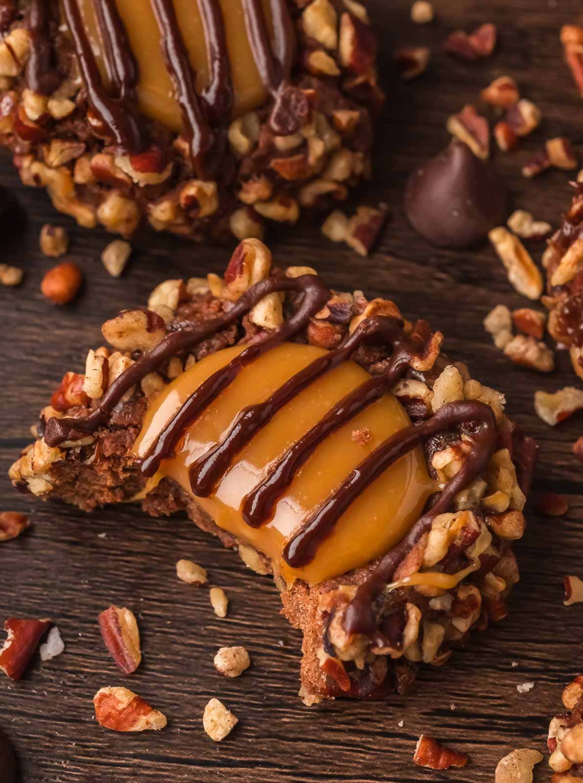 Turtle Thumbprint Cookie with bite showing soft chocolate center and gooey caramel.