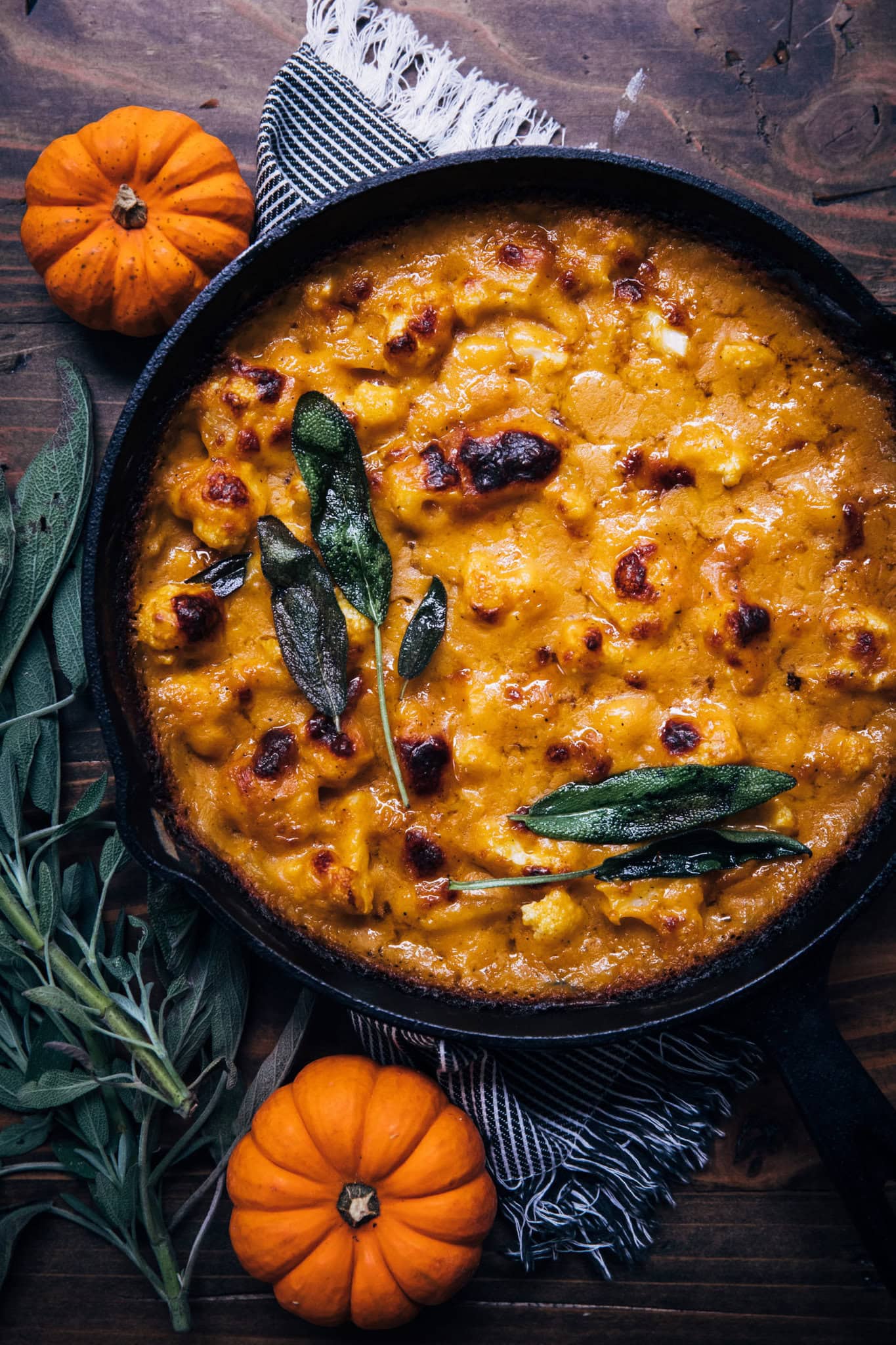 A cast iron pan full of delicious pumpkin gratin with melted cheese on top.