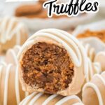 A group of Biscoff truffles on a white surface with cookie crumbs and melted white chocolate in the background.