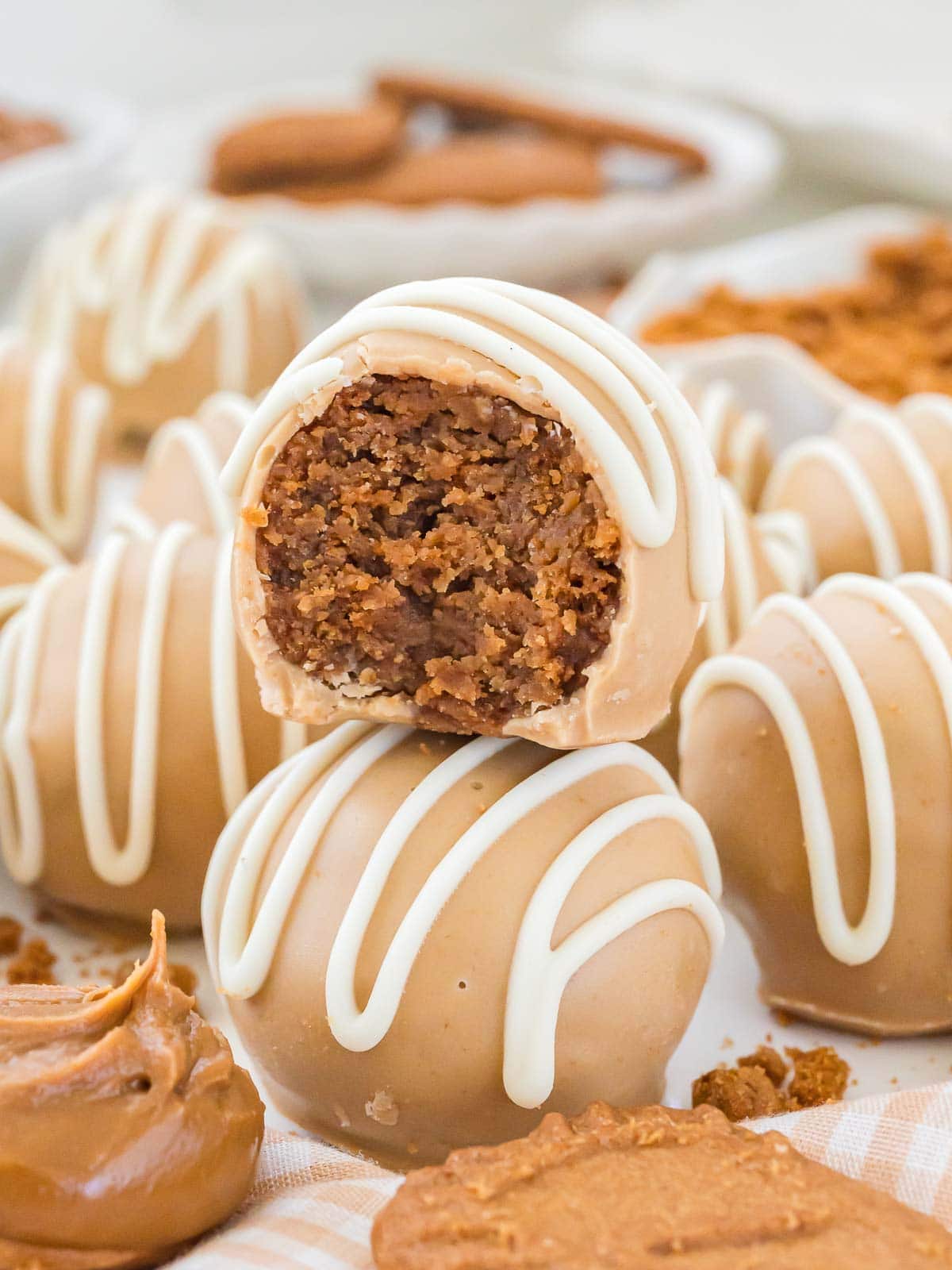 Bite taken from a Biscoff truffle showing the soft cookie butter center surrounded by a creamy white chocolate shell.
