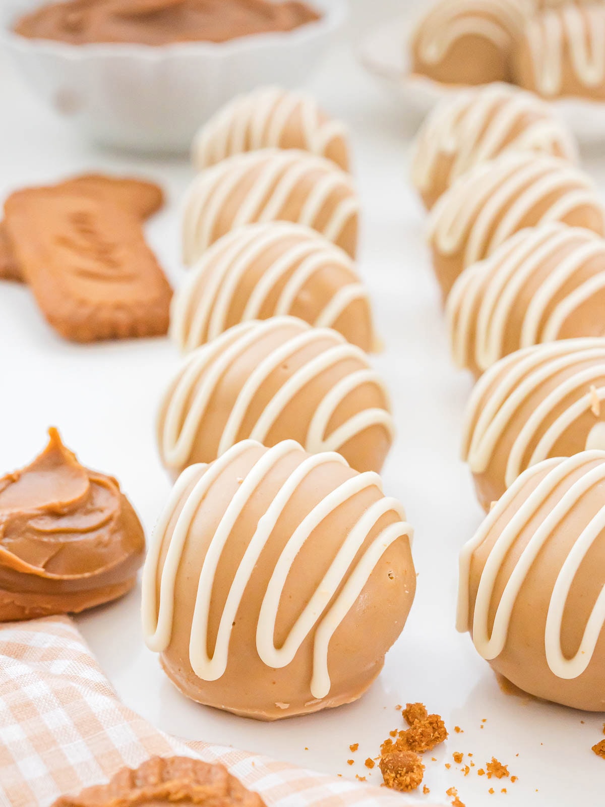Rows of Biscoff truffles coated in cookie butter and white chocolate with a creamy white drizzle on top.