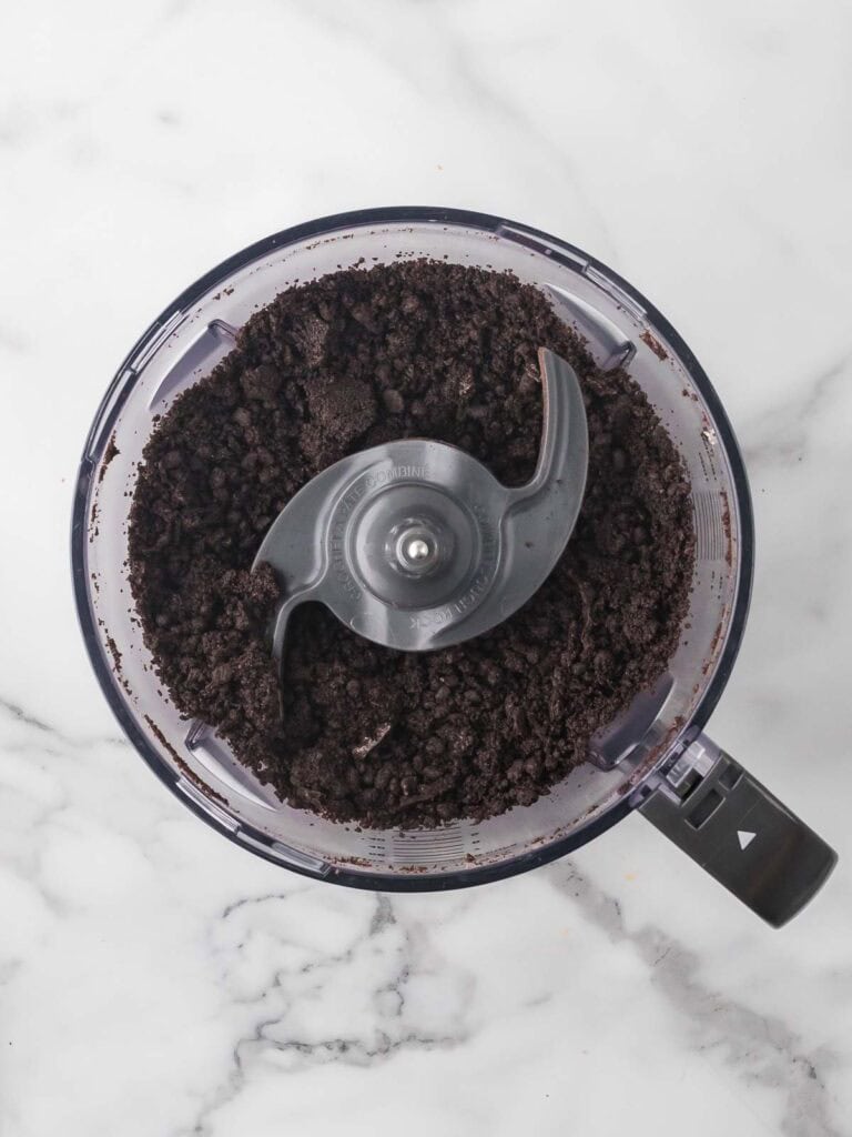 Crushed Oreo cookies pulsed into fine crumbs in a food processor, ready to mix for homemade Oreo truffles.