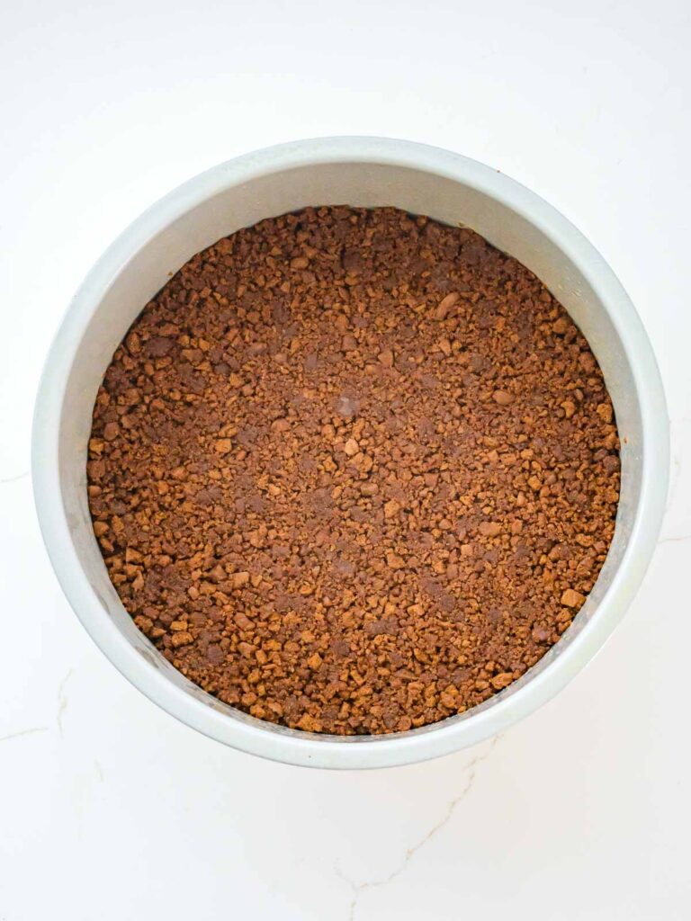 Biscoff cookie crust pressed evenly into a springform pan to chill before adding filling.