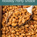Spoon lifting roasted spiced peanuts from a baking sheet by Tessie's Table.