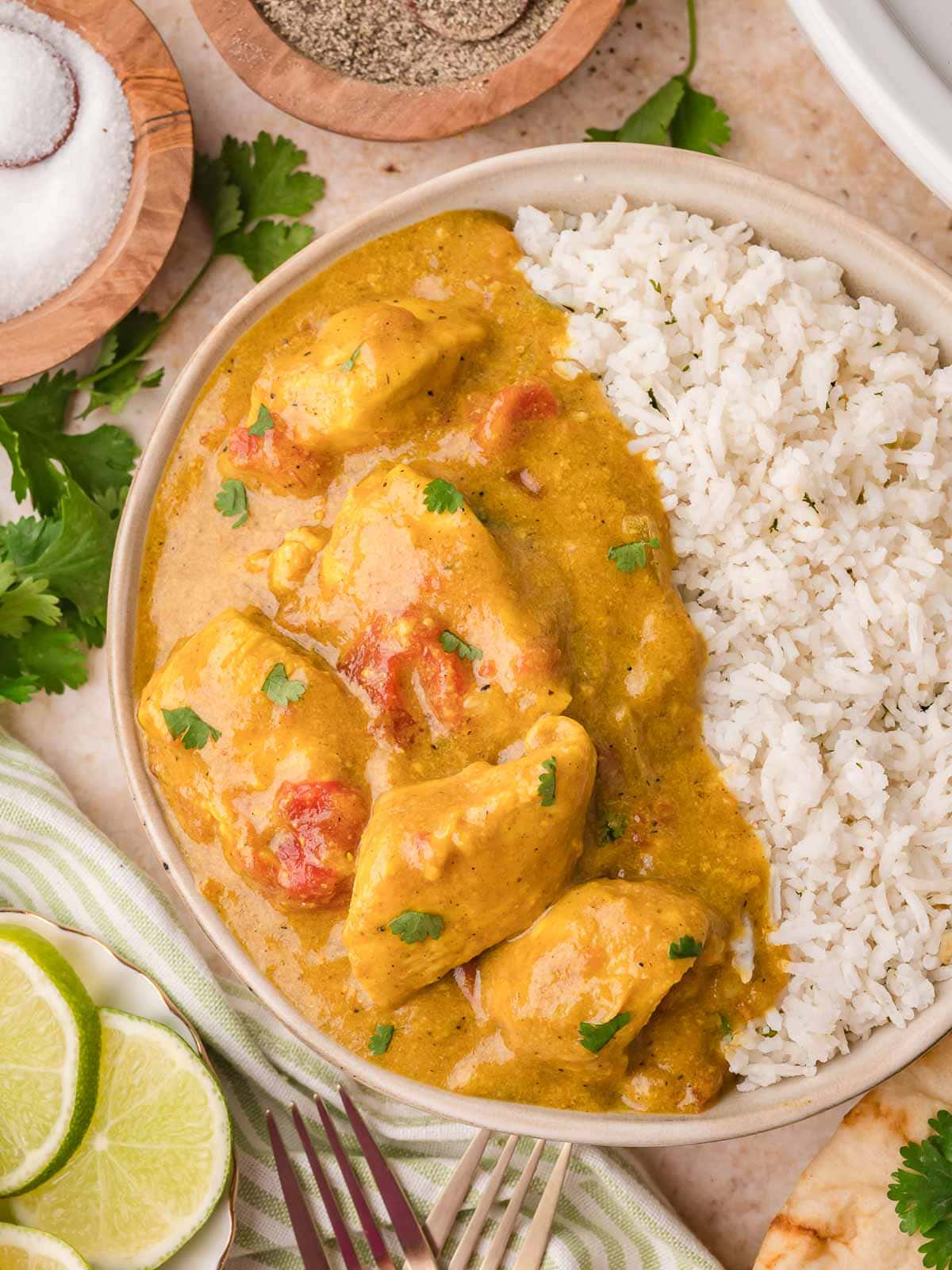 Bowl of slow cooker coconut chicken curry served with white rice, topped with fresh cilantro in a creamy coconut sauce.